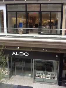 Exterior of Aldo store in a bustling mall, showcasing trendy shoes and accessories.