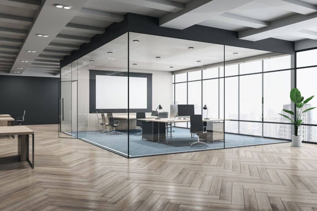 A modern office with glass walls and wooden floors