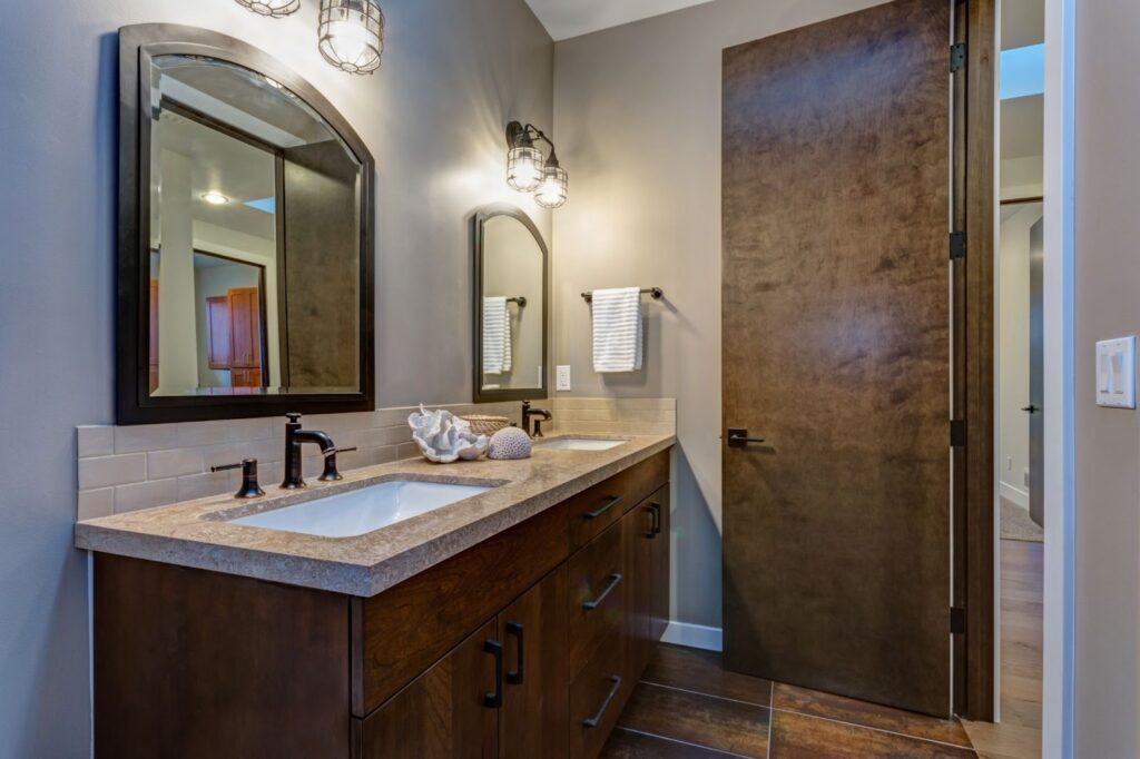 Bathroom with dual sinks, large mirror, and custom mirrors for replacement